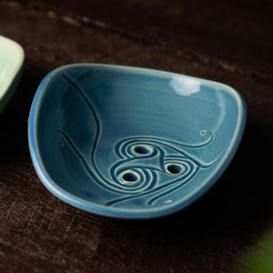 Eco-friendly blue soap holder on dark background