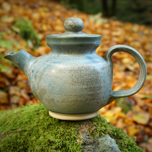 Stoneware tea in blue and brown sitting on rock part of tea gift set