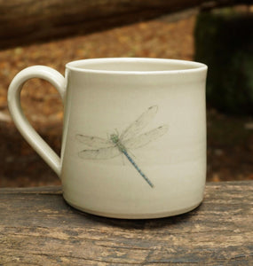 Reverse view of Dragon Fly mug sitting on a tree branch in woods