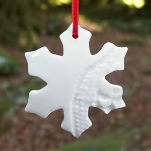 Cream snowflake cut out of Christmas tree hanging on tree
