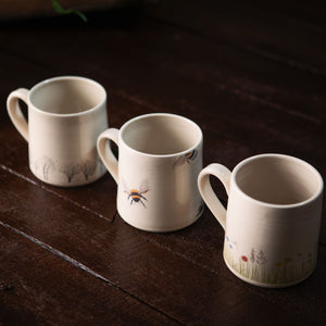 A gift of 3 practical and stylish sustainable mugs, Wildflower, Tree and Bee Pottery Mugs.  Each mug is crafted by hand and bees, flowers and trees are hand painted onto each mug.