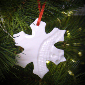 ceramic christmas decoration hanging on a christmas tree with lights
